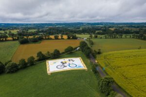 La tela piu grande del mondo che celebra il campione Van Aert in azione sulla sua bici dalliconica ruota blu Swapfiets creata dagli youtuber olandesi Tour de Tetiema 2
